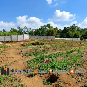 Lahan Kosong dan Pagar Panel Beton di Bawah Langit Cerah